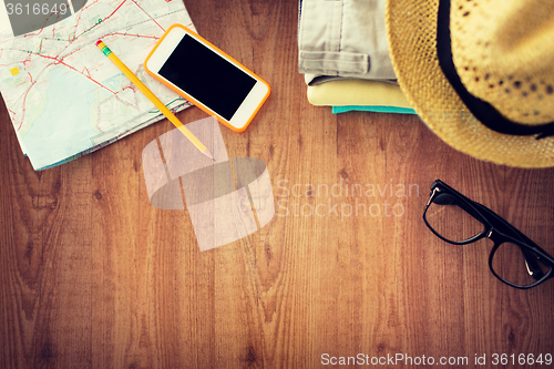 Image of close up of summer clothes and travel map on table