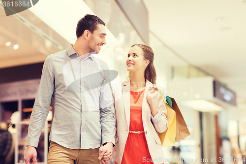 Image of happy young couple with shopping bags in mall