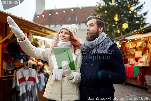 Image of happy couple walking with tablet pc in old town