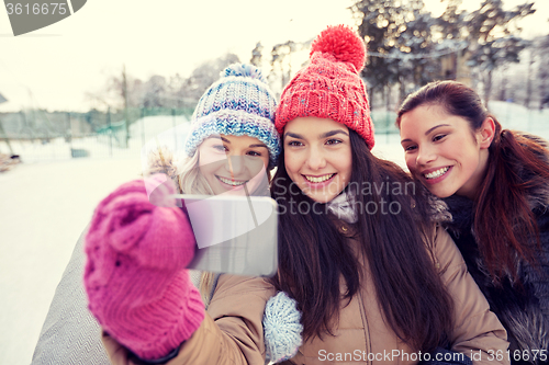 Image of happy teenage girls taking selfie with smartphone
