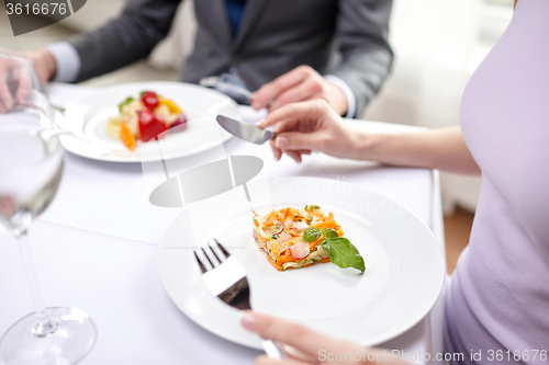 Image of close up of couple eating appetizers at restaurant