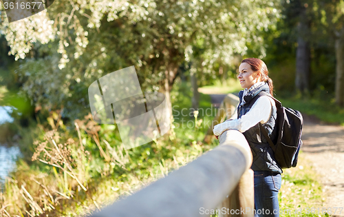 Image of happy woman with backpack outdoors