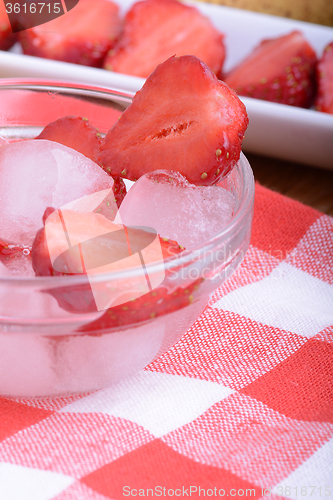 Image of A slice of red strawberry on glass plate in party theme background