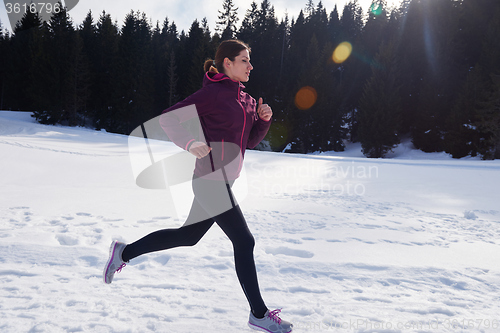 Image of yougn woman jogging outdoor on snow in forest