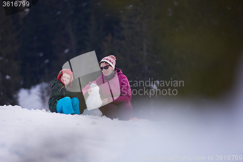 Image of happy family building snowman