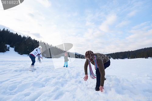 Image of happy family playing together in snow at winter