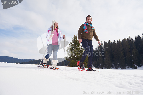 Image of couple having fun and walking in snow shoes