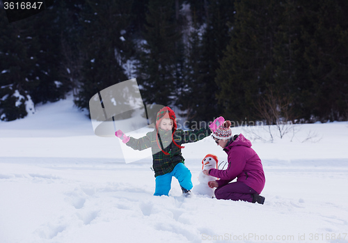 Image of happy family building snowman