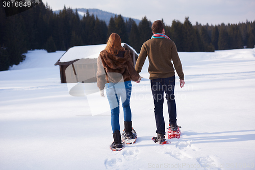 Image of couple having fun and walking in snow shoes