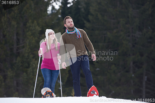 Image of couple having fun and walking in snow shoes