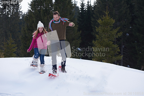 Image of couple having fun and walking in snow shoes