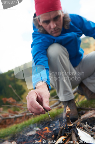 Image of hiking man try to light fire