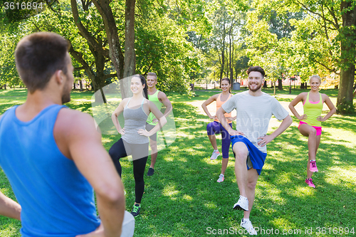 Image of group of friends or sportsmen exercising outdoors