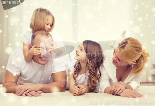 Image of smiling parents and two little girls at home