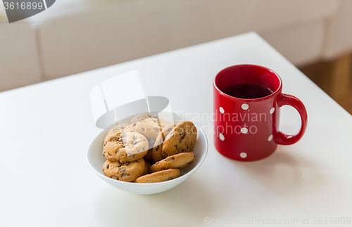 Image of close up of oat cookies and red tea cup on table