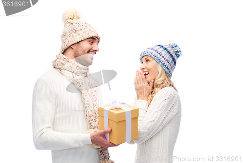 Image of smiling couple in winter clothes with gift box
