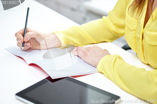 Image of close up of woman with tablet pc and notebook