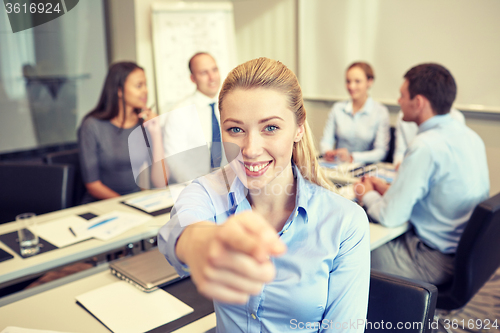 Image of group of smiling businesspeople meeting in office