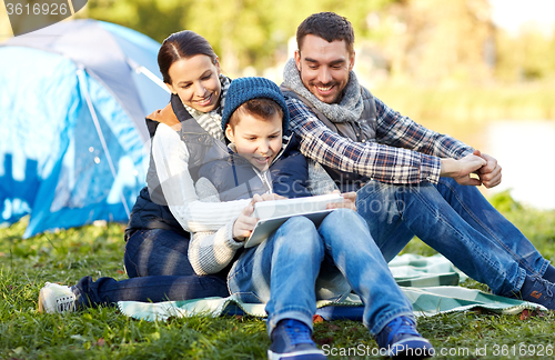 Image of happy family with tablet pc and tent at camp site