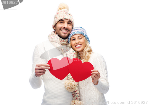 Image of smiling couple in winter clothes with red hearts