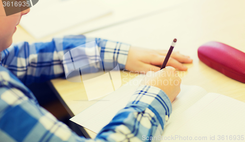 Image of close up of schoolboy writing test at school