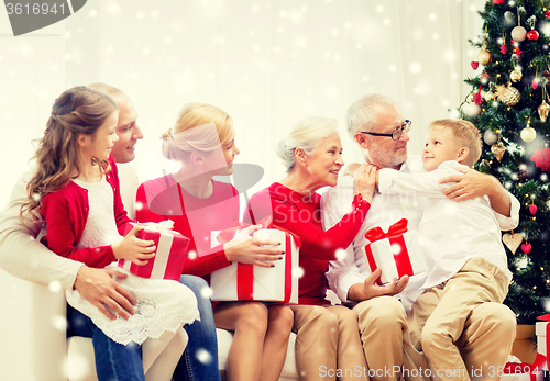 Image of smiling family with gifts at home