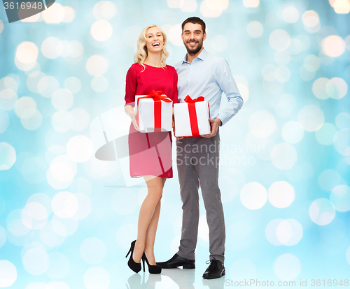 Image of happy couple with gift boxes over lights
