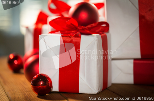 Image of close up of gift boxes and red christmas balls