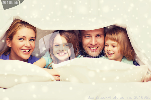 Image of happy family with two kids under blanket at home