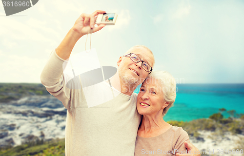 Image of senior tourists couple with camera photographing