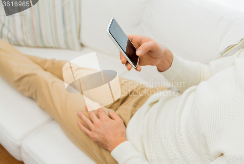 Image of close up of man with smartphone at home