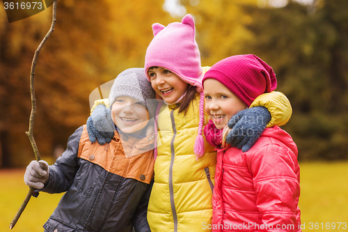 Image of group of happy children hugging in autumn park