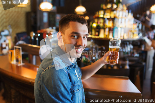 Image of happy man drinking beer at bar or pub