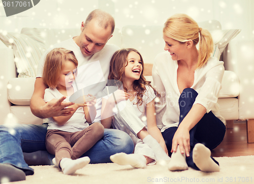 Image of smiling parents and two little girls at home
