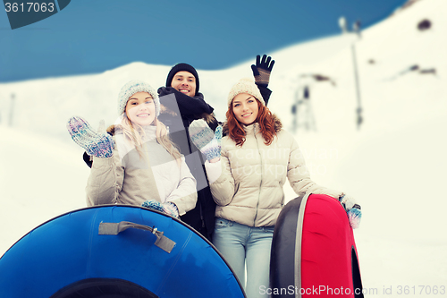 Image of group of smiling friends with snow tubes