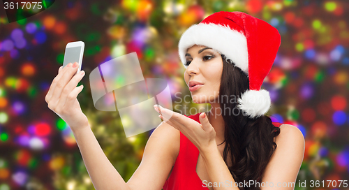 Image of woman in santa hat taking selfie by smartphone