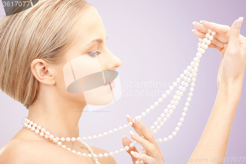 Image of beautiful woman with pearl necklace over violet