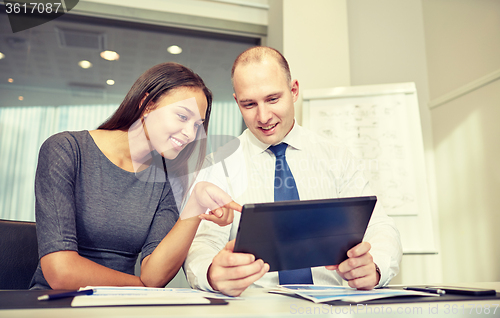 Image of smiling businesspeople with tablet pc in office