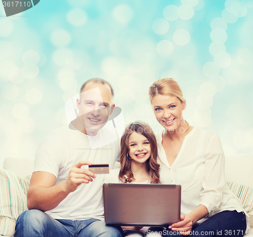 Image of happy family with laptop computer and credit card