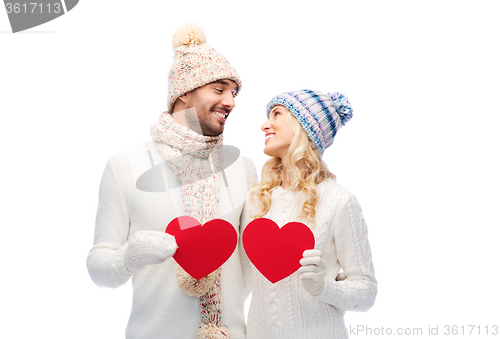 Image of smiling couple in winter clothes with red hearts