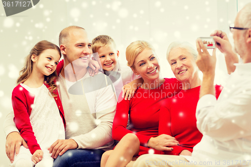 Image of smiling family with camera photographing at home