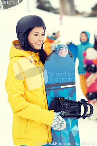 Image of happy friends in helmets with snowboards