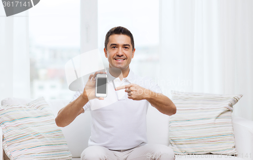 Image of happy man with smartphone at home