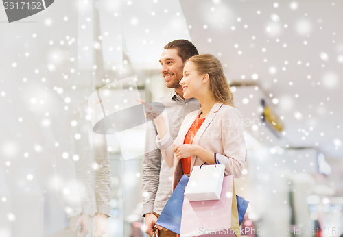 Image of happy young couple with shopping bags in mall