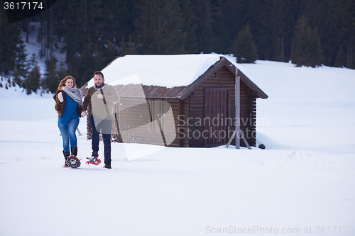 Image of couple having fun and walking in snow shoes