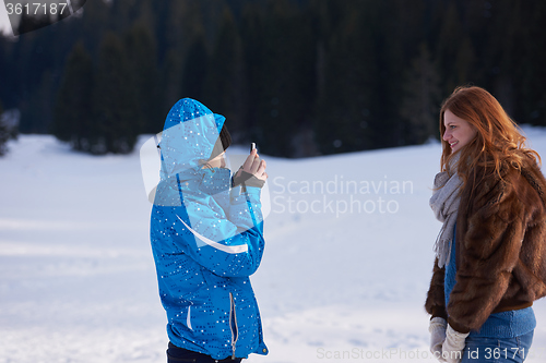 Image of couple having fun and walking in snow shoes