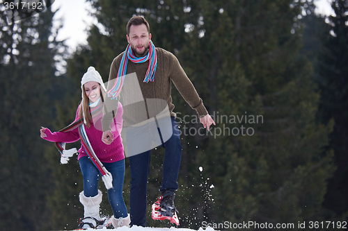 Image of couple having fun and walking in snow shoes