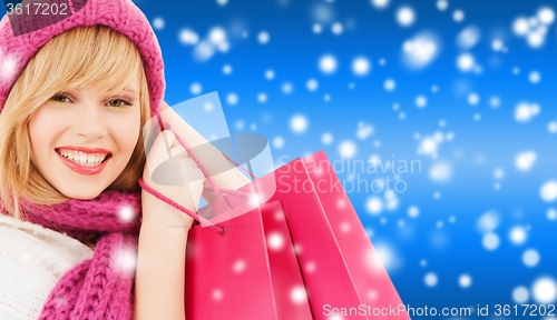 Image of woman in pink hat and scarf with shopping bags