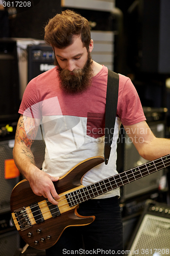 Image of musician or customer with guitar at music store