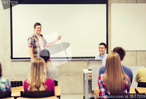 Image of group of students and smiling teacher in classroom